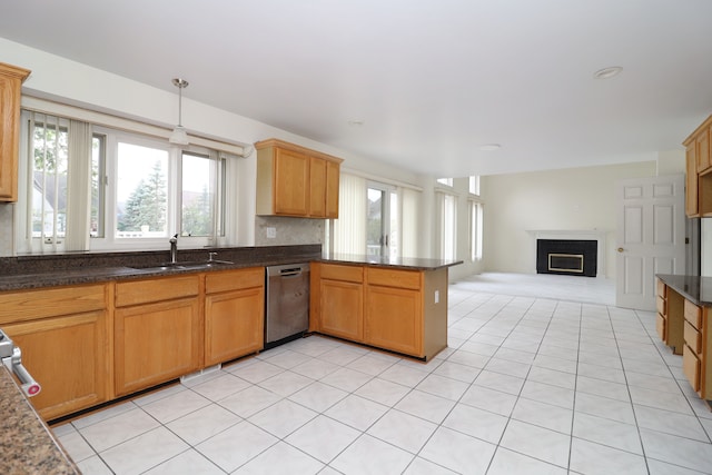 kitchen featuring open floor plan, a peninsula, stainless steel dishwasher, pendant lighting, and a sink