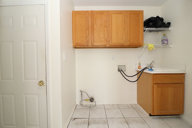 laundry area with light tile patterned floors, washer hookup, cabinet space, and baseboards