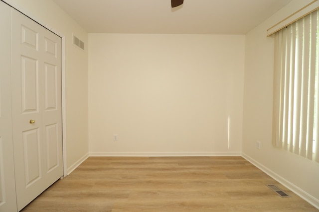 spare room featuring light wood-style floors, baseboards, and visible vents