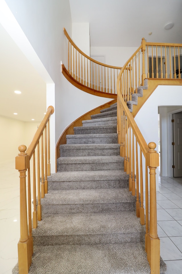 stairway featuring tile patterned flooring and recessed lighting