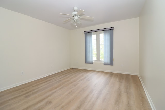 unfurnished room with light wood-style floors, baseboards, and a ceiling fan