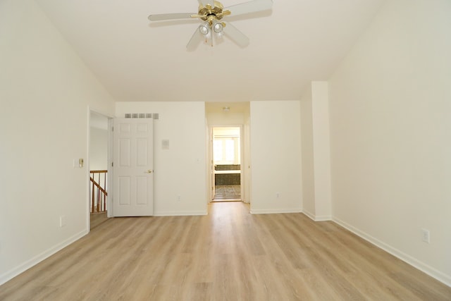 spare room with light wood-style floors, baseboards, visible vents, and a ceiling fan