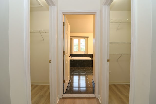 hall with baseboards and wood finished floors