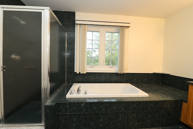 full bath featuring a garden tub and a shower stall