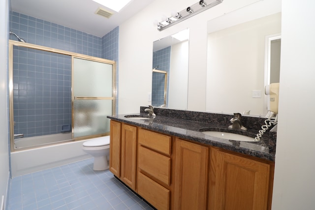 full bath with tile patterned flooring, visible vents, combined bath / shower with glass door, and a sink