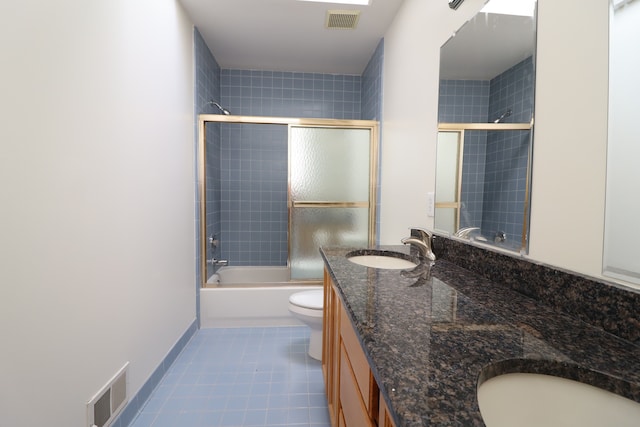 bathroom featuring enclosed tub / shower combo, visible vents, a sink, and toilet