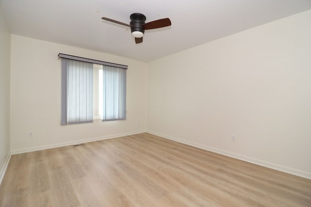 spare room featuring light wood-style floors, baseboards, visible vents, and ceiling fan