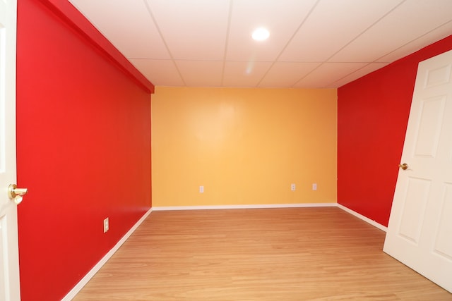 unfurnished room with a drop ceiling, baseboards, and wood finished floors