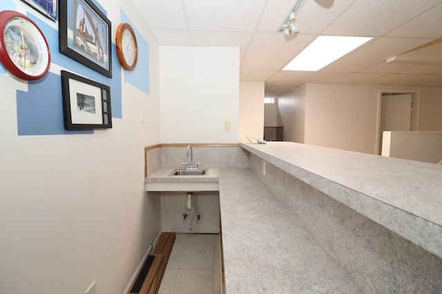 interior space featuring visible vents, a drop ceiling, and a sink