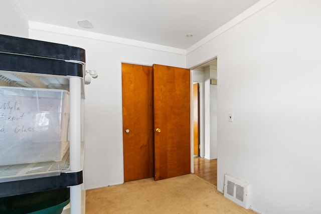 bedroom featuring a closet, light colored carpet, and visible vents