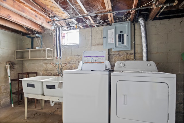 clothes washing area with laundry area, separate washer and dryer, a sink, and electric panel