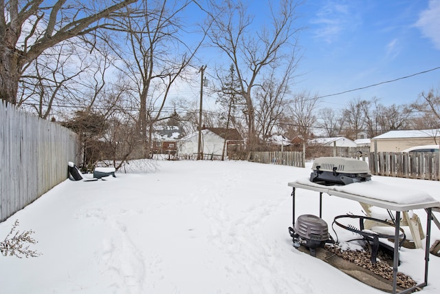 yard layered in snow featuring fence