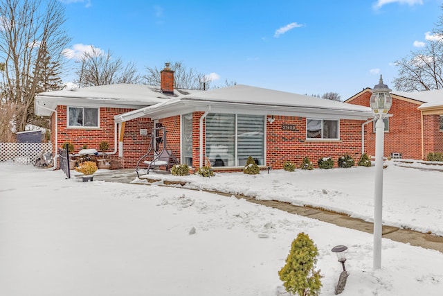 view of front of home featuring brick siding and a chimney