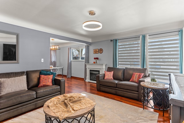 living room featuring dark wood-type flooring and a glass covered fireplace