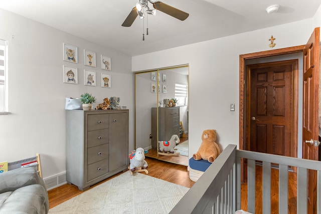 bedroom with a closet, wood finished floors, visible vents, and a ceiling fan