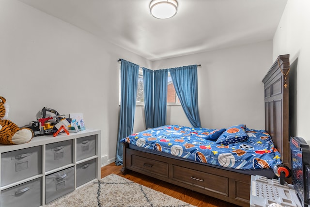 bedroom featuring wood finished floors and baseboards