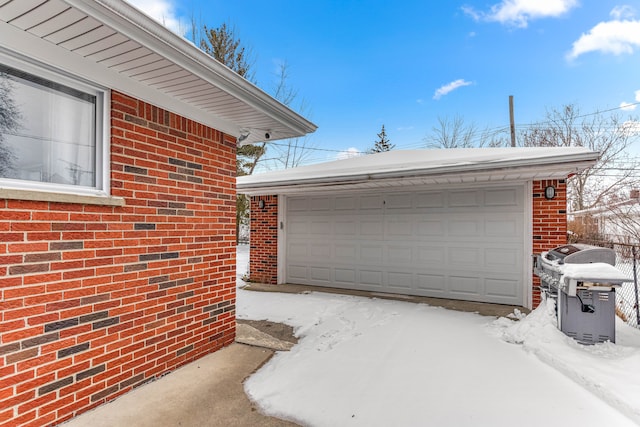 snow covered garage featuring a garage