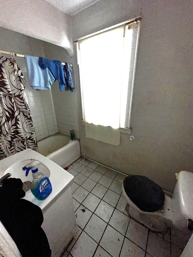 bathroom with shower / bath combination, toilet, and tile patterned floors