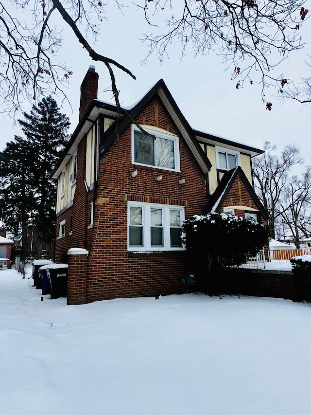 exterior space featuring a chimney and brick siding