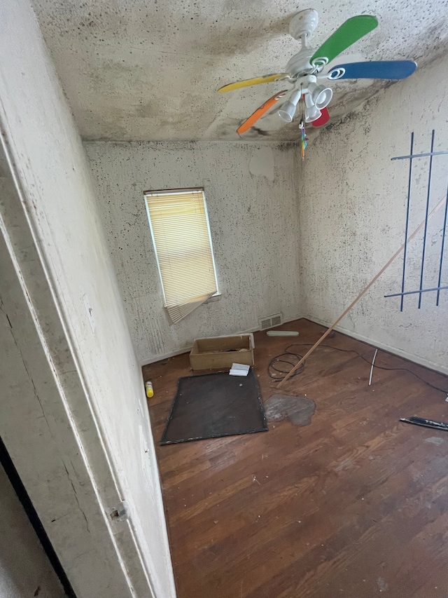 unfurnished room featuring ceiling fan and dark wood-type flooring