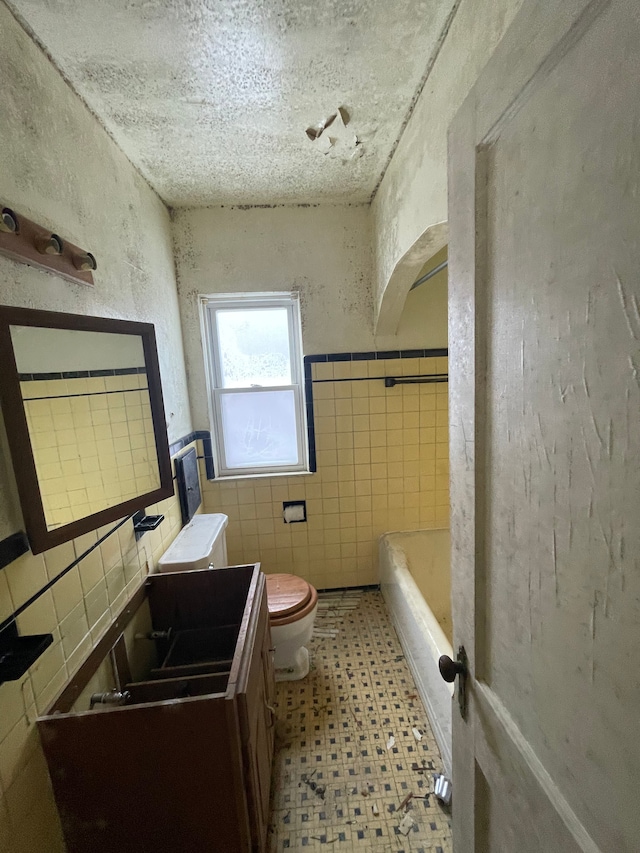 bathroom with vanity, tile walls, toilet, and tile patterned floors