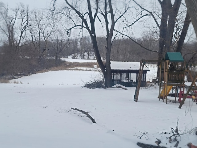 snowy yard featuring a playground