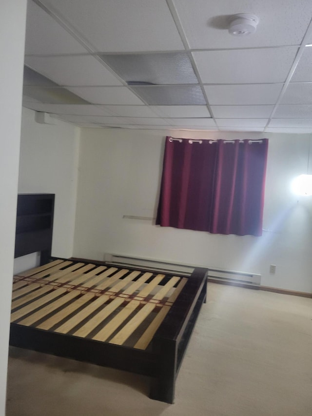 unfurnished bedroom featuring a drop ceiling and baseboards