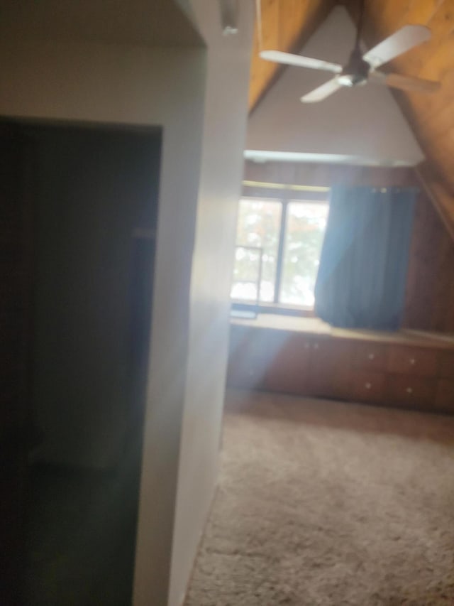 corridor with vaulted ceiling and carpet floors