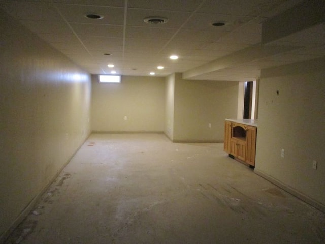 basement featuring a paneled ceiling and visible vents