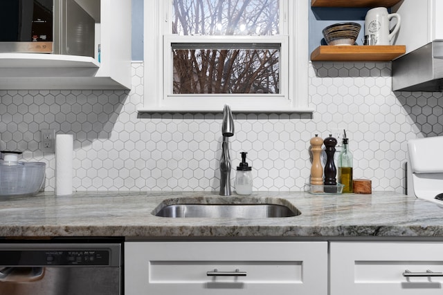 kitchen with open shelves, stainless steel dishwasher, white cabinets, a sink, and light stone countertops