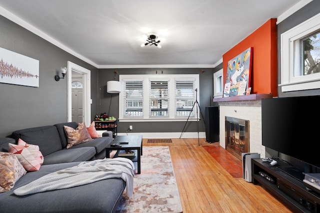 living room featuring baseboards, a fireplace, and light wood finished floors