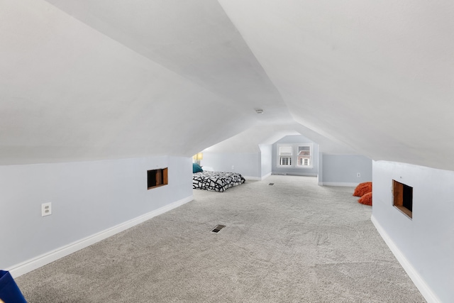 additional living space featuring lofted ceiling, carpet floors, visible vents, and baseboards