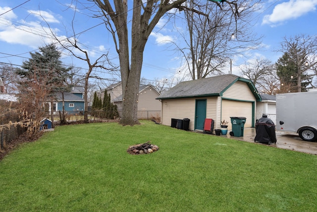 view of yard featuring an outbuilding, fence, and a garage