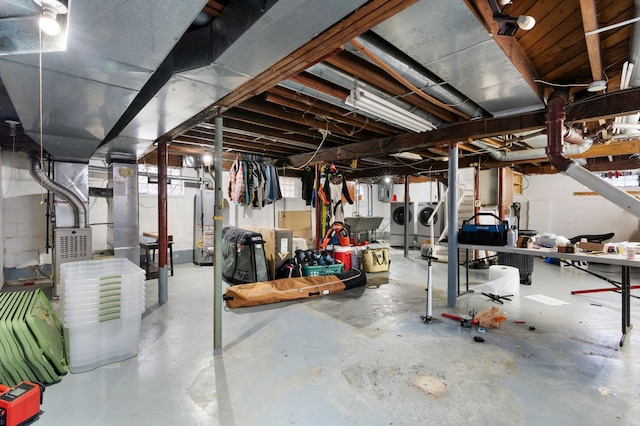 basement featuring water heater and washing machine and clothes dryer