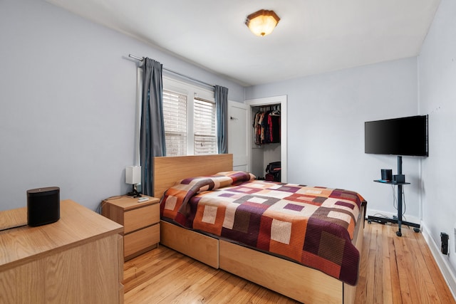 bedroom featuring a closet, light wood-style flooring, and baseboards