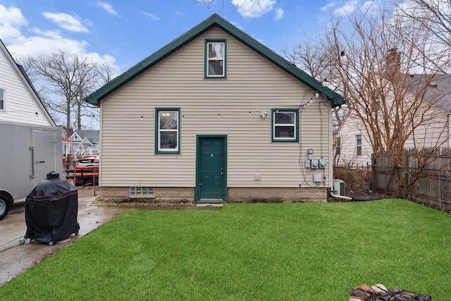 rear view of property featuring a patio, central AC unit, a lawn, and fence