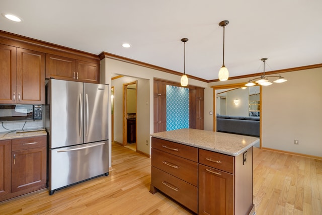 kitchen with black microwave, light wood-style floors, baseboards, and freestanding refrigerator
