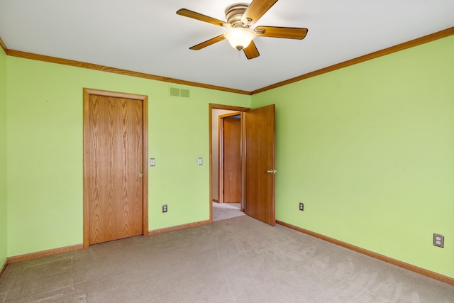 unfurnished bedroom with baseboards, ornamental molding, carpet, and visible vents