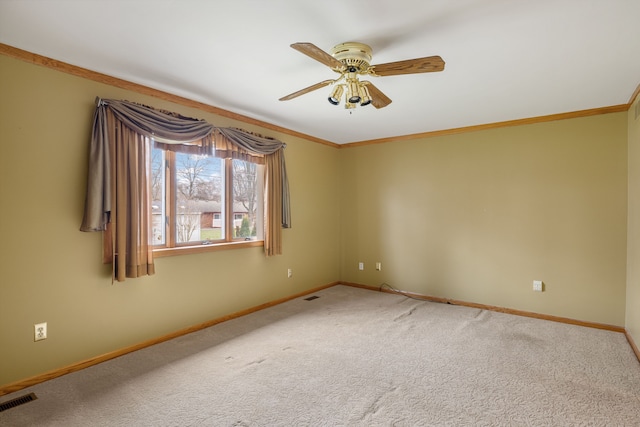 carpeted spare room with baseboards, ceiling fan, ornamental molding, and visible vents