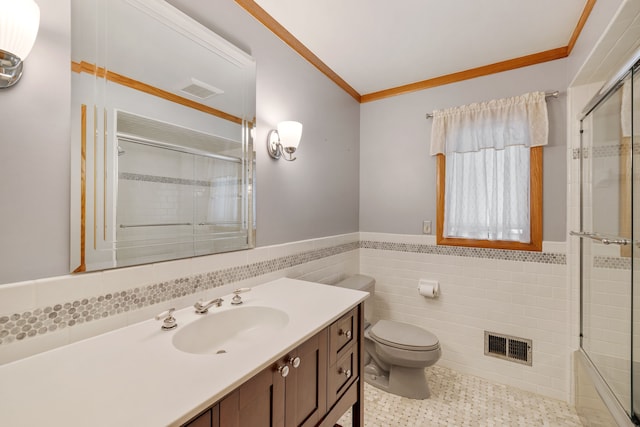 full bath featuring toilet, a wainscoted wall, tile walls, visible vents, and tiled shower