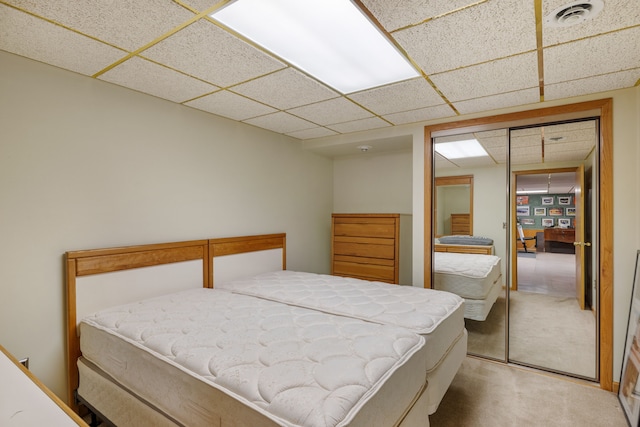 bedroom featuring visible vents, carpet, a closet, and a paneled ceiling