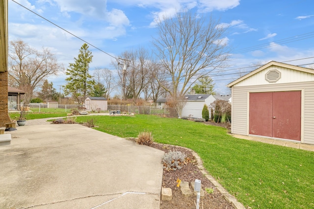 view of yard featuring a storage unit, an outdoor structure, a fenced backyard, and a patio