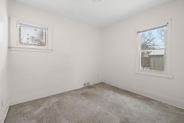 carpeted spare room featuring visible vents