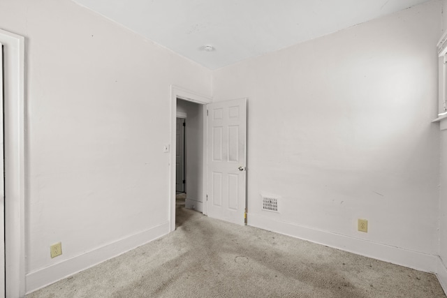 spare room with carpet, visible vents, and baseboards