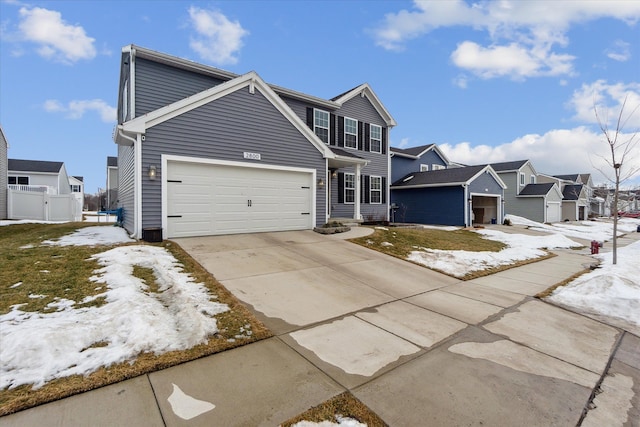 traditional-style home with concrete driveway, an attached garage, fence, and a residential view