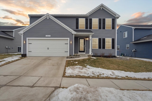 traditional-style home with a garage, a front yard, and concrete driveway