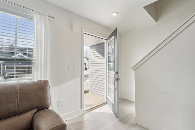 living area featuring light wood-style floors and baseboards