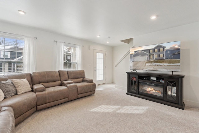 living room with light carpet, baseboards, a glass covered fireplace, and recessed lighting