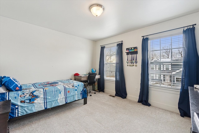 bedroom with baseboards, visible vents, and light colored carpet