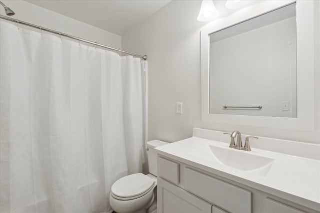 bathroom featuring toilet, a shower with shower curtain, and vanity